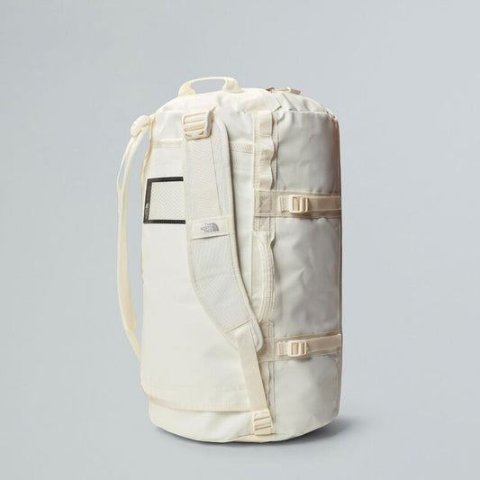 White backpack with a rolled-up mat on a gray background