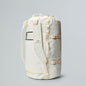 White backpack with a rolled-up mat on a gray background
