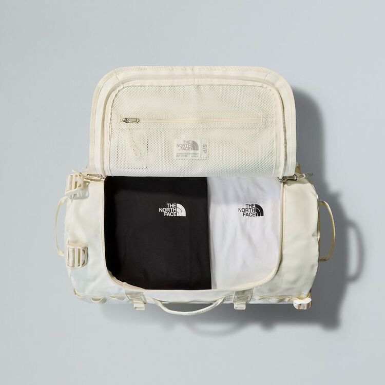 Light beige travel bag with 'The North Face' logo on a gray background
