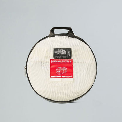 Round duffel bag with The North Face label on a gray background