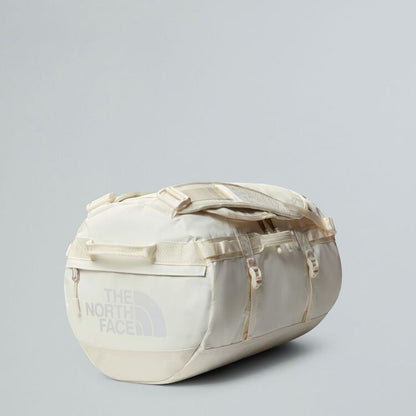 Beige duffel bag with 'The North Face' logo on a light gray background