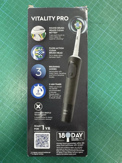 Vitality Pro electric toothbrush packaging on a green cutting mat