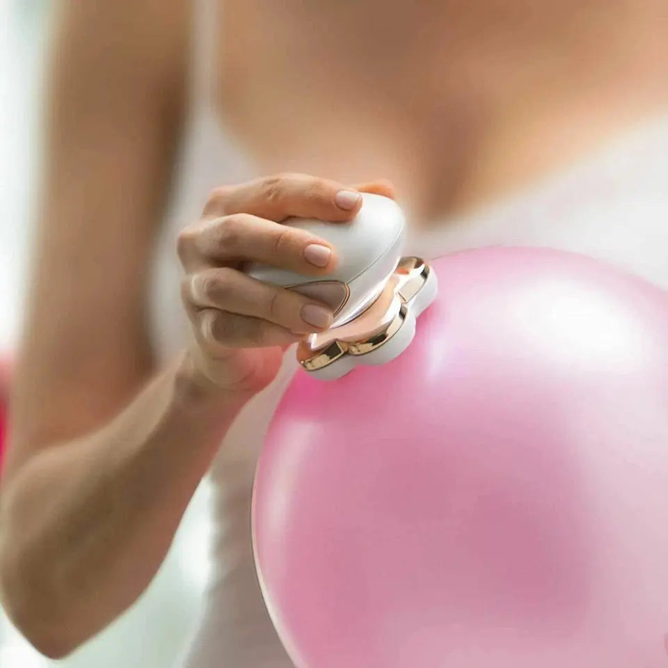 Hand using a small device on a large pink balloon